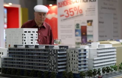Un visitante observa una maqueta en un salón inmobiliario.