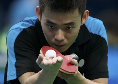 El jugador de tenis de mesa de Qatar, Li Ping, se prepara para sacar la pelota frente al jugador de Hungría Adam Pattantyus.