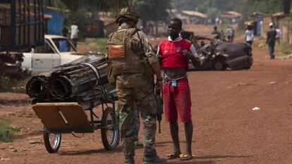 Un militar franc&eacute;s registra a un hombre en el distrito de Miskine, en Bangui.