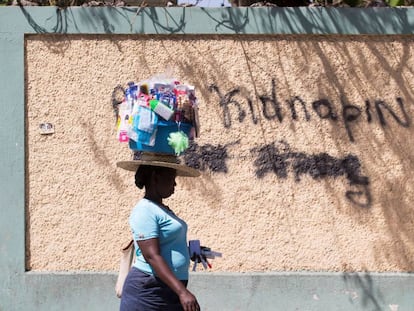 Una mujer pasa junto a un grafiti en el que se lee “Abajo los secuestros” el 16 de febrero en Puerto Príncipe (Haití).