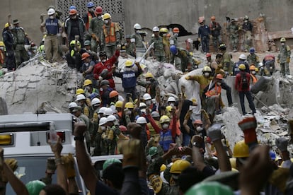 Miembros de los equipos de rescate levantan los puños para pedir silencio durante las tareas de búsqueda de supervivientes entre los restos de un edificio en Ciudad de México, que colapsó tras el terremoto de magnitud 7,1 que afectó varias zonas del país el pasado martes.