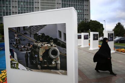 Una mujer pasa por una exposición al aire libre que muestra imágenes del golpe de estado fallido que tuvo lugar hace un año en Turquía, en Estambul.