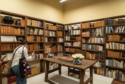 Una mujer hace una foto al escritorio que utilizaba Octavio Paz, exhibido junto con la biblioteca del autor en la nueva Casa Marie José y Octavio Paz.