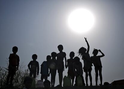 Un grupo de niños espera para coger agua potable en un caluroso día de verano en Nueva Delhi, India.