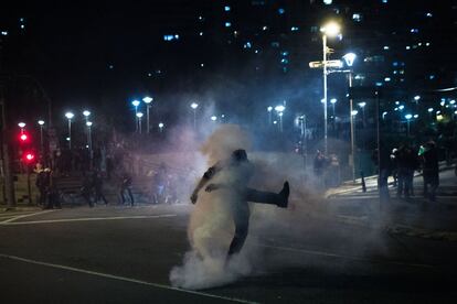 Un simpatizante de Dilma Rousseff golpea una botella de gas lacrimógeno durante el enfrentamiento con la policía en las calles de São Paulo (Brasil).