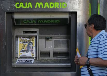 Un cajero de Caja Madrid cubierto por un folleto de protesta.