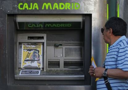 Un cajero de Caja Madrid cubierto por un folleto de protesta. 