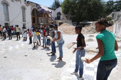 Niños haitianos retiran escombros en una iglesia de Puerto Príncipe.