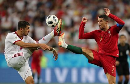Cristiano Ronaldo y Majid Hosseini luchan por un balón durante el partido de grupos entre Irán y Portugal, el 25 de junio de 2018.