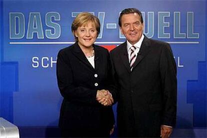 La democristiana Angela Merkel y el socialdemócrata Gerhard Schröder se saludan antes del debate.