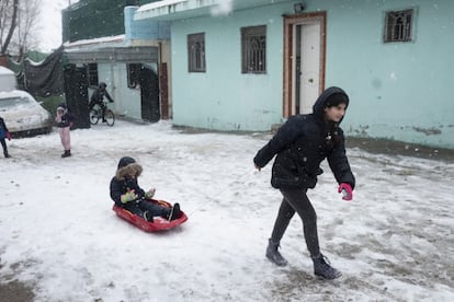 Niños juegan en la nieve dentro de una finca de la Cañada Real, a las afueras de Madrid.