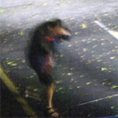 Un hombre trata de protegerse de una rácha de viento en Pensacola, Florida.
