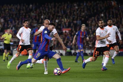 Lionel Messi, marca un gol ante la oposición de Aymen Abdennour, centrocampista de Valencia.
