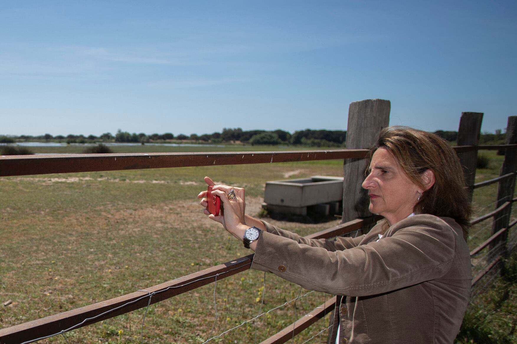 La vicepresidenta toma una fotografía con su móvil de las marismas de Doñana.