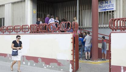 Varias personas esperan la apertura de la oficina para el DNI en una comisaría de Sevilla.