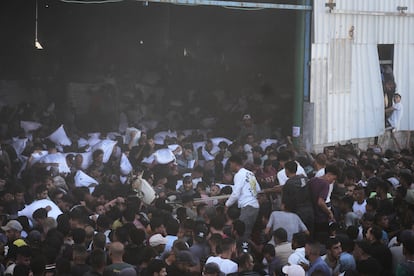 Ciudadanos palestinos cargan sacos de harina tras asaltar un almacén del Programa Mundial de Alimentos de la ONU en Zawaida, en el centro de la franja de Gaza, este miércoles.