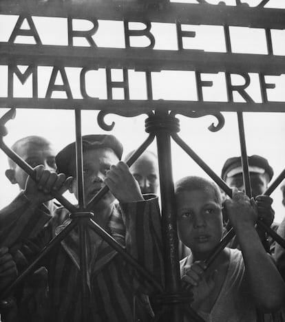 Prisioneros del campo de concentración de Dachau miran a través de la valla, en una imagen sin datar.