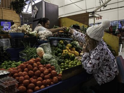 Una mujer compra verdura en un mercado de CIudad de México.