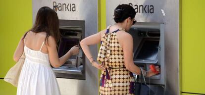 Dos mujeres sacan dinero en un cajero de Bankia en Madrid.