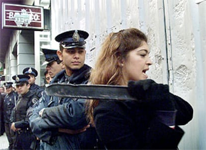 Una ciudadana golpea la fachada de una sucursal bancaria en Buenos Aires en protesta por el<i> </i><b></b><i>corralito.</i>