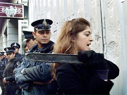 Una ciudadana golpea la fachada de una sucursal bancaria en Buenos Aires en protesta por el<i> </i><b></b><i>corralito.</i>