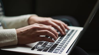 Persona que escribe en el teclado de su ordenador portátil