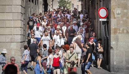 Un carrer ple de turistes prop de la plaça Sant Jaume.