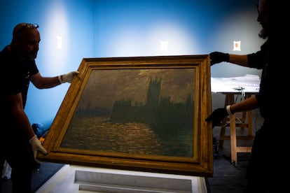 Staff unwrap the painting 'Parliament. Reflections in the Thames’ to hang it at CentroCentro.