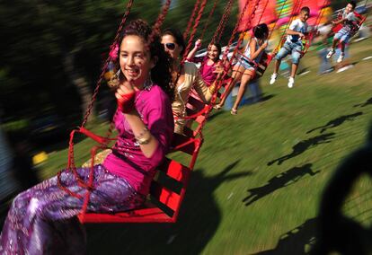 Unos jóvenes se divierten en una de las atracciones disponible en la romería.