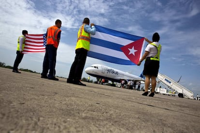 Trabajadores del Aeropuerto Internacional Abel Santamaría, en Santa Clara (Cuba), reciben con una bandera cubana y una estadounidense a los pasajeros del primer vuelo comercial entre ambos países. 