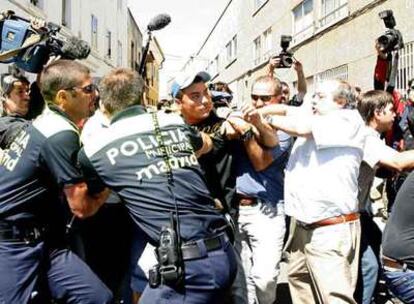 La policía contiene a un allegado de la víctima que intenta abalanzarse sobre familiares del agresor, que todavía no había sido detenido.