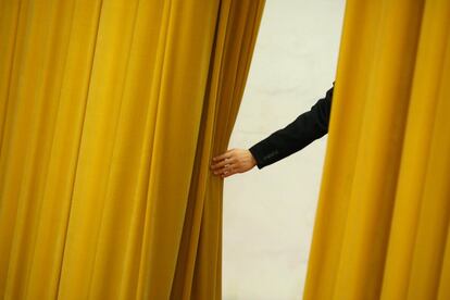 Un miembro del personal de seguridad sostiene el telón durante la sesión de apertura de la Asamblea Popular Nacional (APN) en el Gran Palacio del Pueblo en Pekín (China), el 5 de marzo.