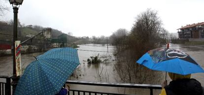 Unos jovenes observan este sábado el nivel del río Urumea a su paso por la localidad de Astigarra (Guipúzcoa). 