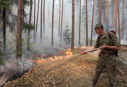 Un soldado ruso apaga un fuego en la región rusa de Shatura.