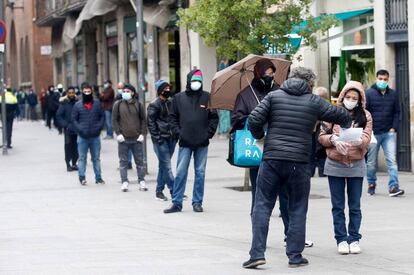 Cues a l'oficina de Serveis Socials al barri del Raval, a Barcelona, durant la crisi del coronavirus.