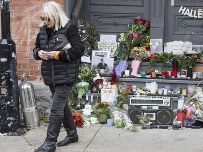 Una mujer frente al altar improvisado que han formado los fans afuera de la casa de Leonard Cohen en Montreal.