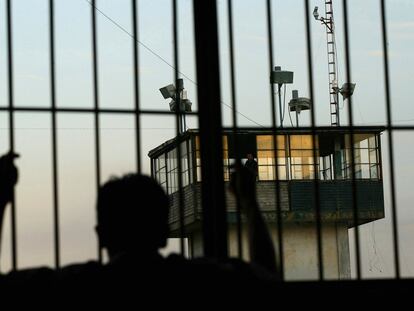 Un recluso mira desde detrás de las rejas  una torre de seguridad en la prisión estatal de Nayarit, en Tepic (México).