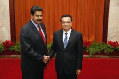 El presidente venezolano, Nicolas Maduro (izda), estrecha la mano del primer ministro chino, Li Keqiang (dcha), hoy en el Gran Palacio del Pueblo en Pekín (China).