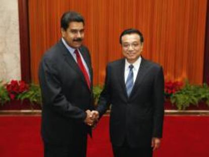 El presidente venezolano, Nicolas Maduro (izda), estrecha la mano del primer ministro chino, Li Keqiang (dcha), hoy en el Gran Palacio del Pueblo en Pekín (China).