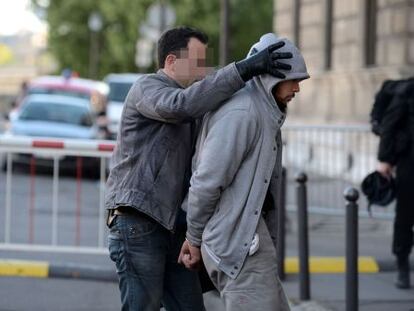 El detenido, a su llegada a la sede central de la policía en París.