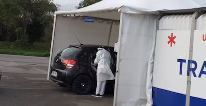 Carpa de Transinsa en la que se ha instalado un Autocovid en Gijón, con coches esperando a la realización de las PCR.