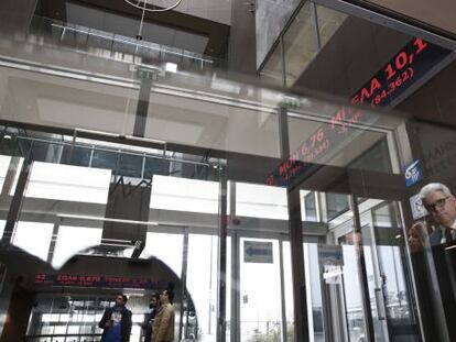 Empleados de la Bolsa de Atenas miran este jueves los índices en rojo.