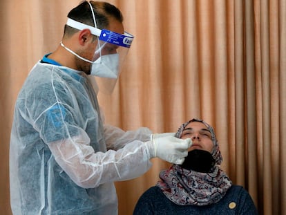 Un sanitario palestino toma una muestra a una mujer para hacerle un test de coronavirus en el municipio de Dura, Cisjornadia, el 8 de enero.