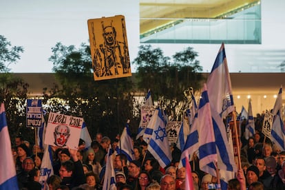 Manifestantes israelíes levantan banderas nacionales y pancartas durante una concentración en Tel Aviv, este sábado, para exigir la dimisión del Gobierno y la convocatoria de elecciones anticipadas.