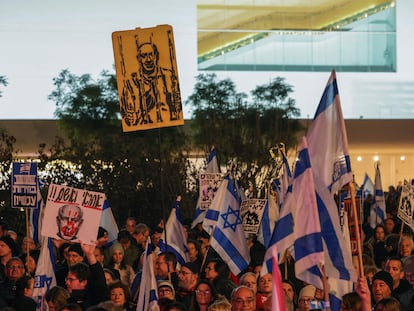 Manifestantes israelíes levantan banderas nacionales y pancartas durante una concentración en Tel Aviv, este sábado, para exigir la dimisión del Gobierno y la convocatoria de elecciones anticipadas.