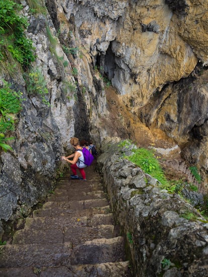 Varias excursionistas descienden las escaleras que llevan hasta el faro del Caballo.