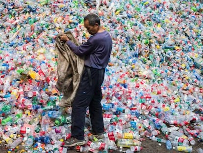 Trabalhador classifica garrafas de plástico para reciclar em Pequim.