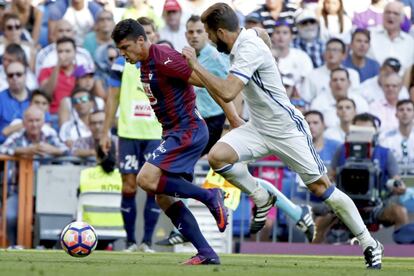 El defensa del Eibar, Ander Capa (i), controla la pelota ante el defensa del Real Madrid, Nacho Fernández (d)
