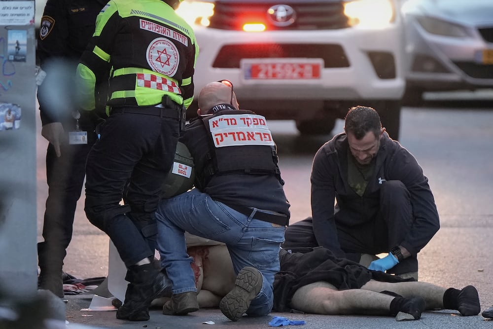 The body of a man who attacked and injured several pedestrians with a knife is examined by Israeli police after he was shot during the stabbing incident in Tel Aviv, Israel, Saturday Jan. 18, 2025.(AP Photo/Oded Balilty)