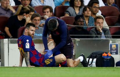 Leo Messi es atendido en la banda durante el partido.